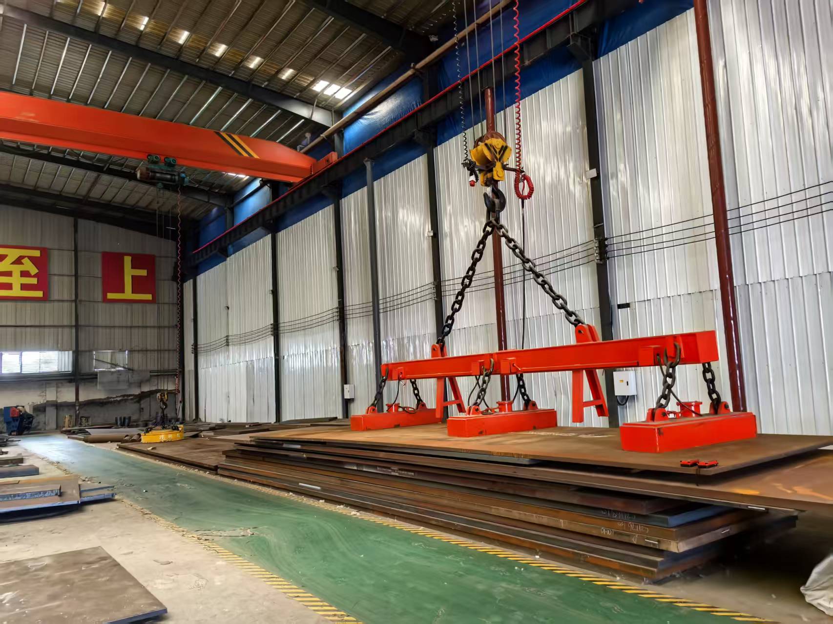 Mass steel plate raw material storage area of our CNC laser cutting factory Self-owned factory warehouse stocked with bulk carbon steel plates, equipped with overhead crane for steel material handling